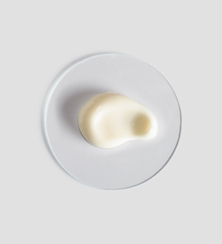 Gros plan sur la texture crémeuse et onctueuse de la "Body Strategist Contour Cream" de Comfort Zone, présenté sur un fond gris clair, illustrant la qualité et l'hydratation intense de la crème.