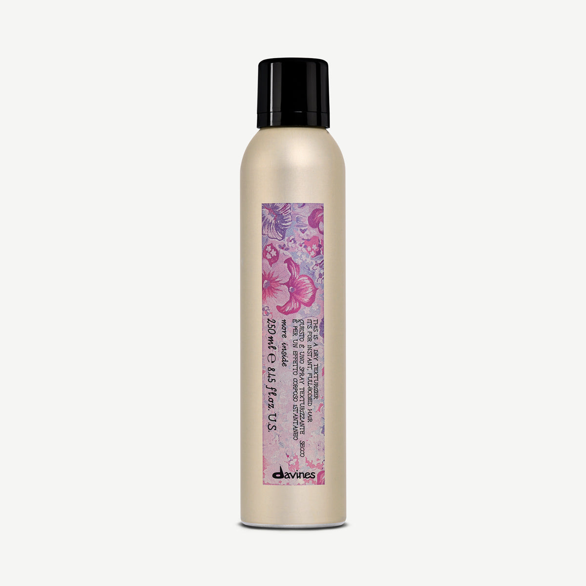 Flacon aérosol doré Davines This Is A Dry Texturizer 250 ml, avec bouchon noir et étiquette florale violette, sur fond blanc.