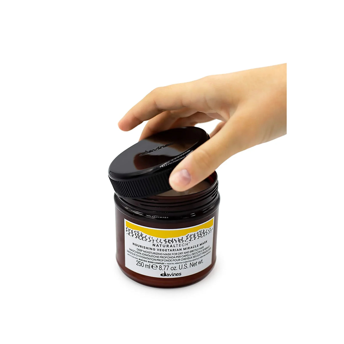Davines Nourishing Vegetarian Miracle Mask 250 ml – une main ouvre le pot du masque