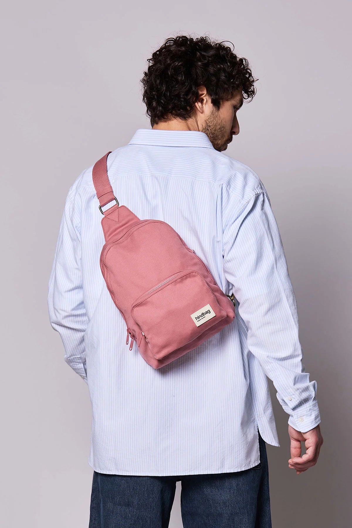 Homme portant le Sling Bag Felix Blush rose au dos en bandouliere