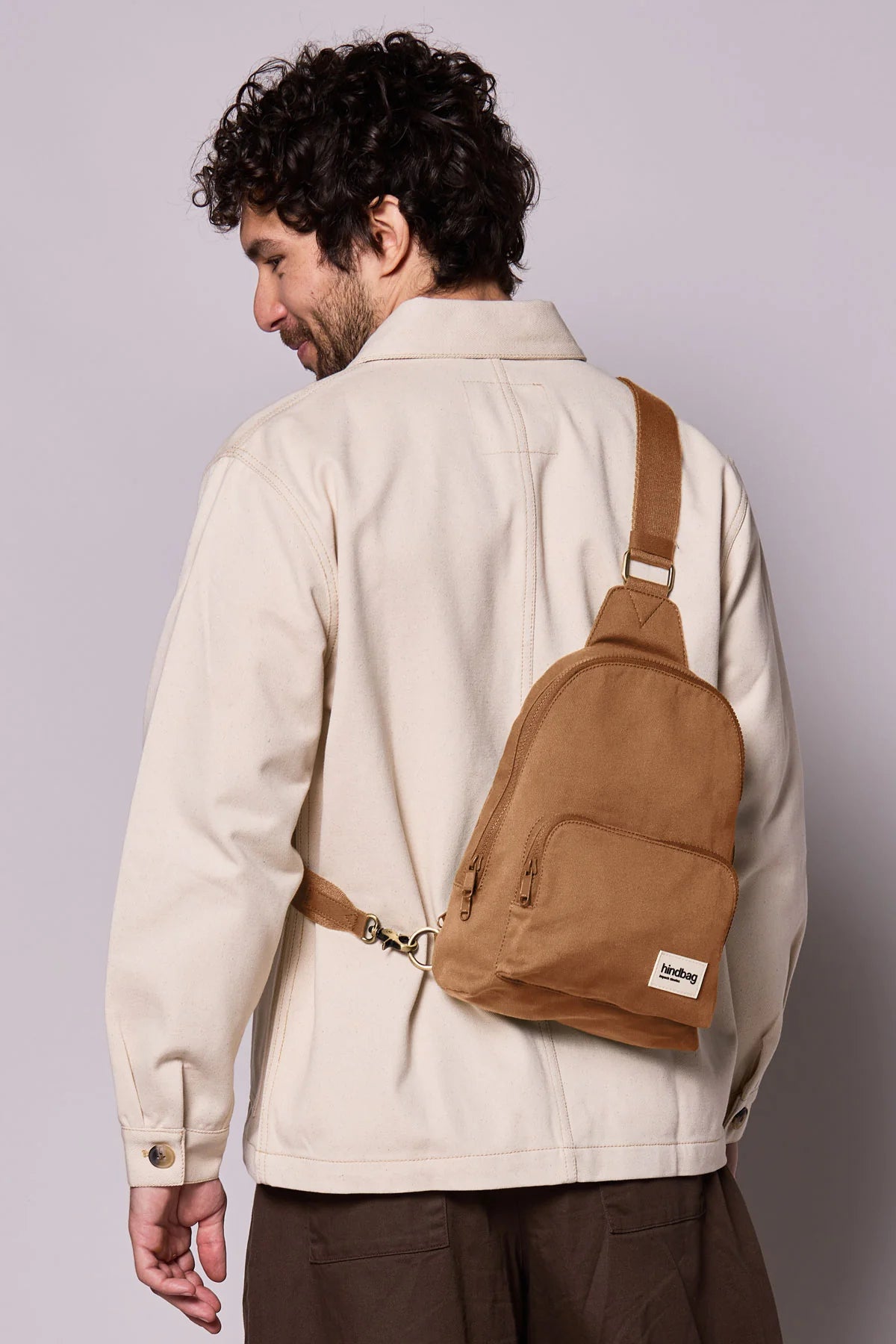 Hindbag Sling Bag Felix coloris Cannelle porté dans le dos par un homme, sac compact et ergonomique pour accompagner les déplacements du quotidien