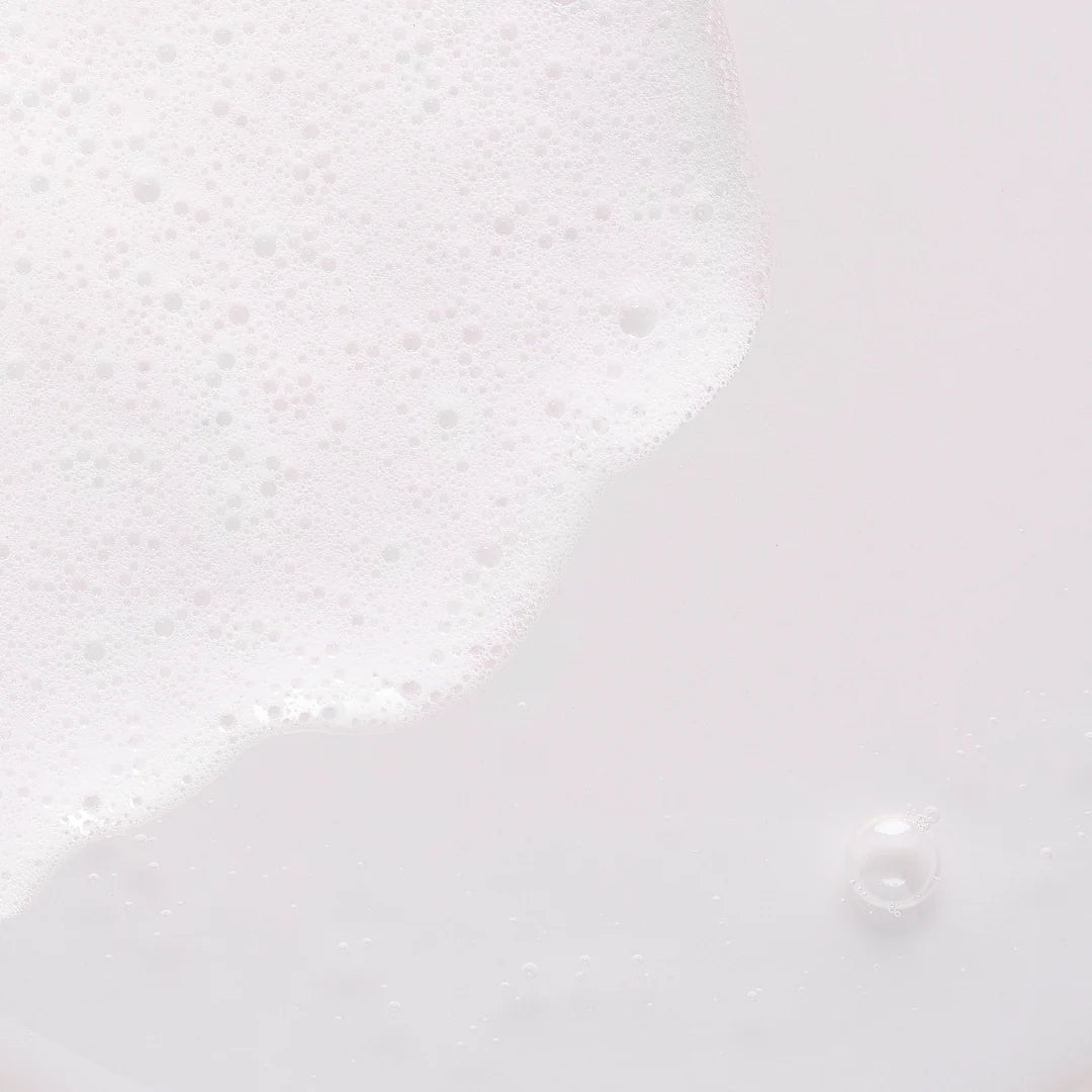 Gros plan sur la mousse blanche du nettoyant visage Comfort Zone Luminant Milky Cleanser.