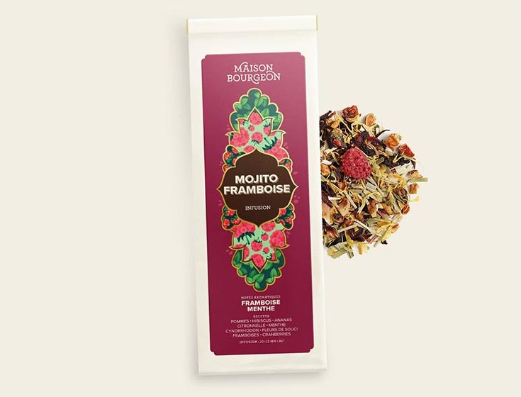 Image du produit "MOJITO FRAMBOISE" de la marque Maison Bourgeon, montrant un paquet de tisane aromatisée avec des framboises et de la menthe. Le paquet est à côté d'un mélange d'infusion en vrac, mettant en valeur les ingrédients naturels visibles dans la tisane.