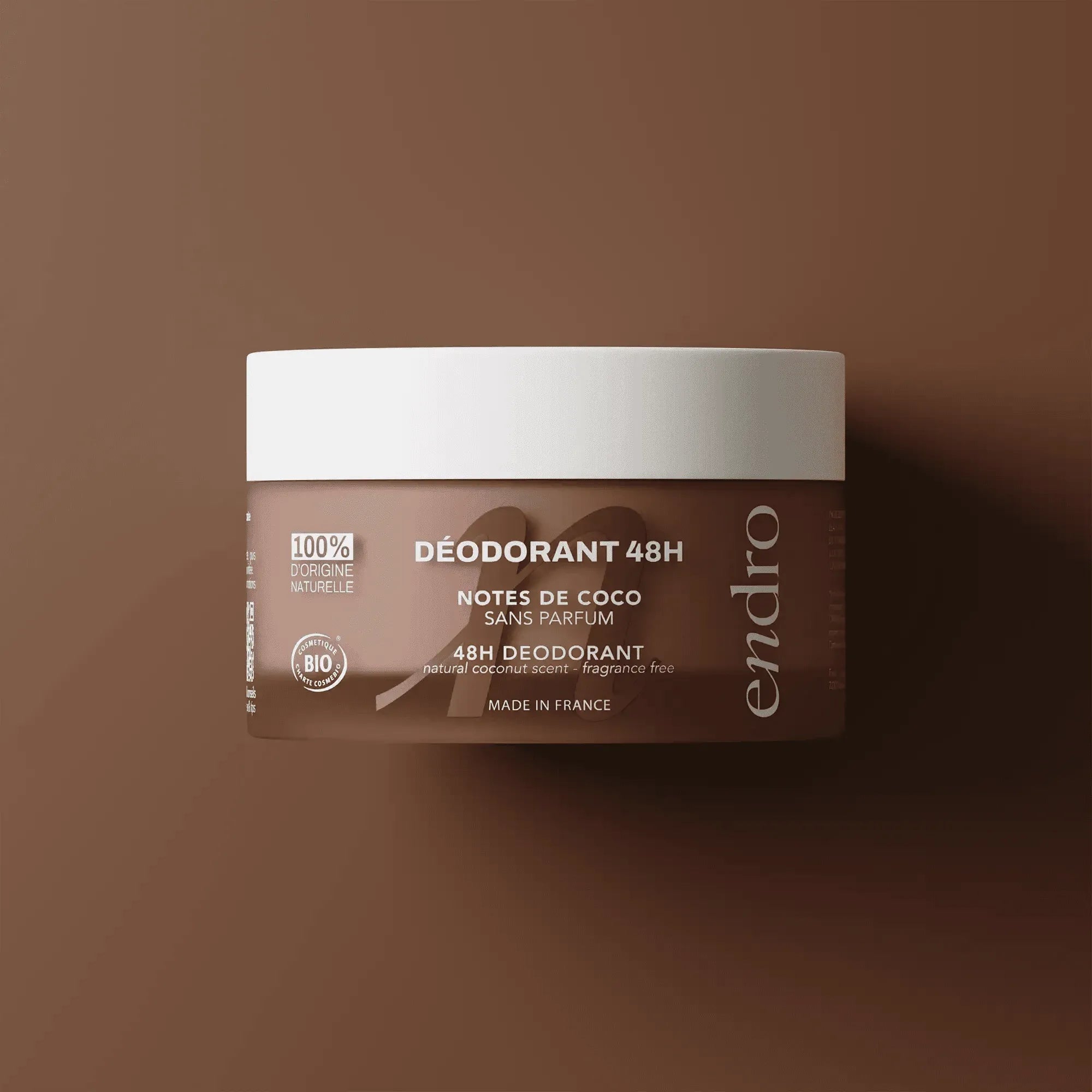 Pot du déodorant baume 48H notes de coco Endro Cosmétiques sur fond marron.