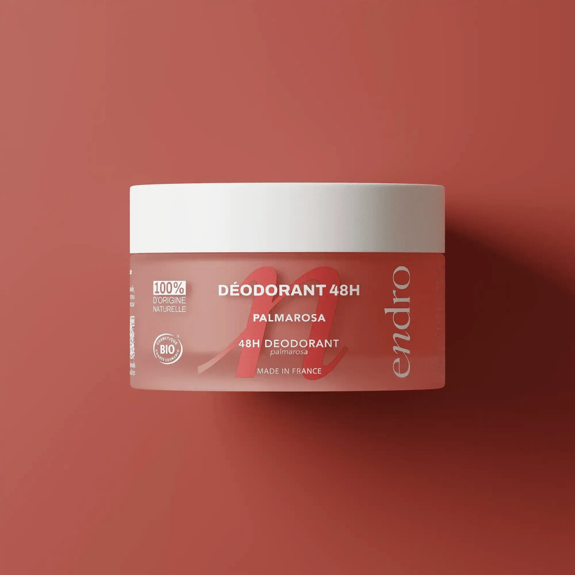 Pot du déodorant baume 48H palmarosa Endro Cosmétiques sur fond corail.