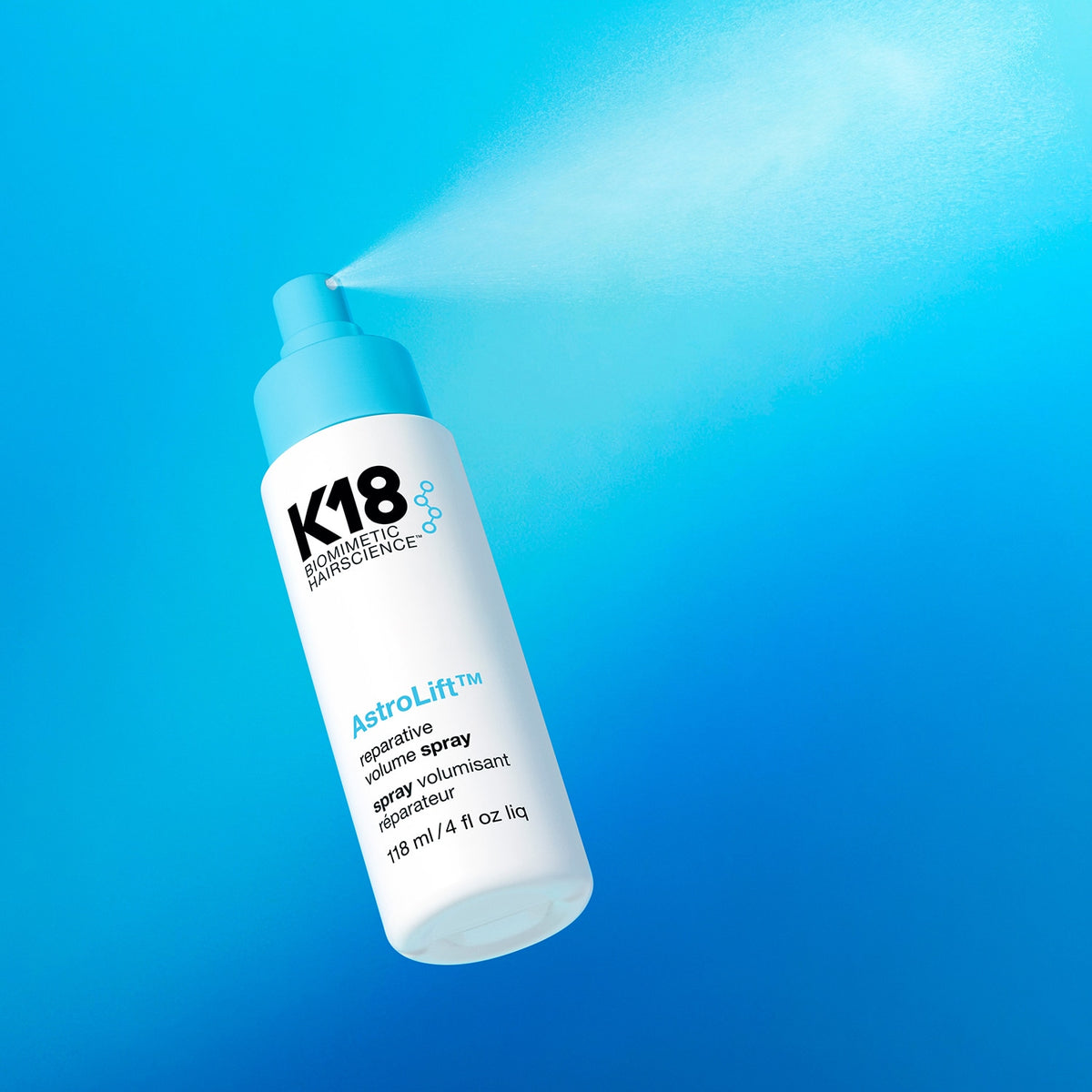 Flacon K18 AstroLift diffusant une fine brume par son vaporisateur bleu, sur fond bleu turquoise.