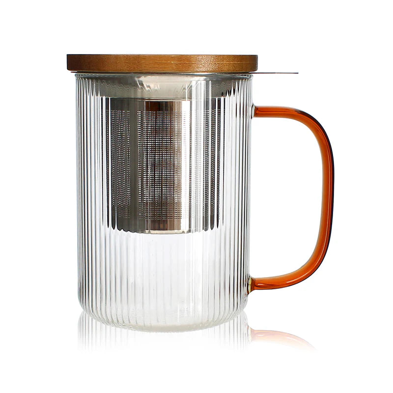Tisaniere de 475 ml en verre borosilicate strie avec anse ambre, filtre inox et couvercle bois, de la marque Ogo Living, presentee sur fond blanc avec reflet.