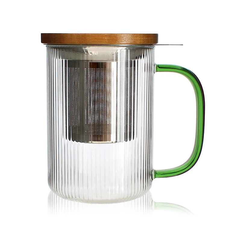 Tisaniere de 475 ml en verre borosilicate strie avec anse verte, filtre inox et couvercle bois, de la marque Ogo Living, presentee sur fond blanc avec reflet.