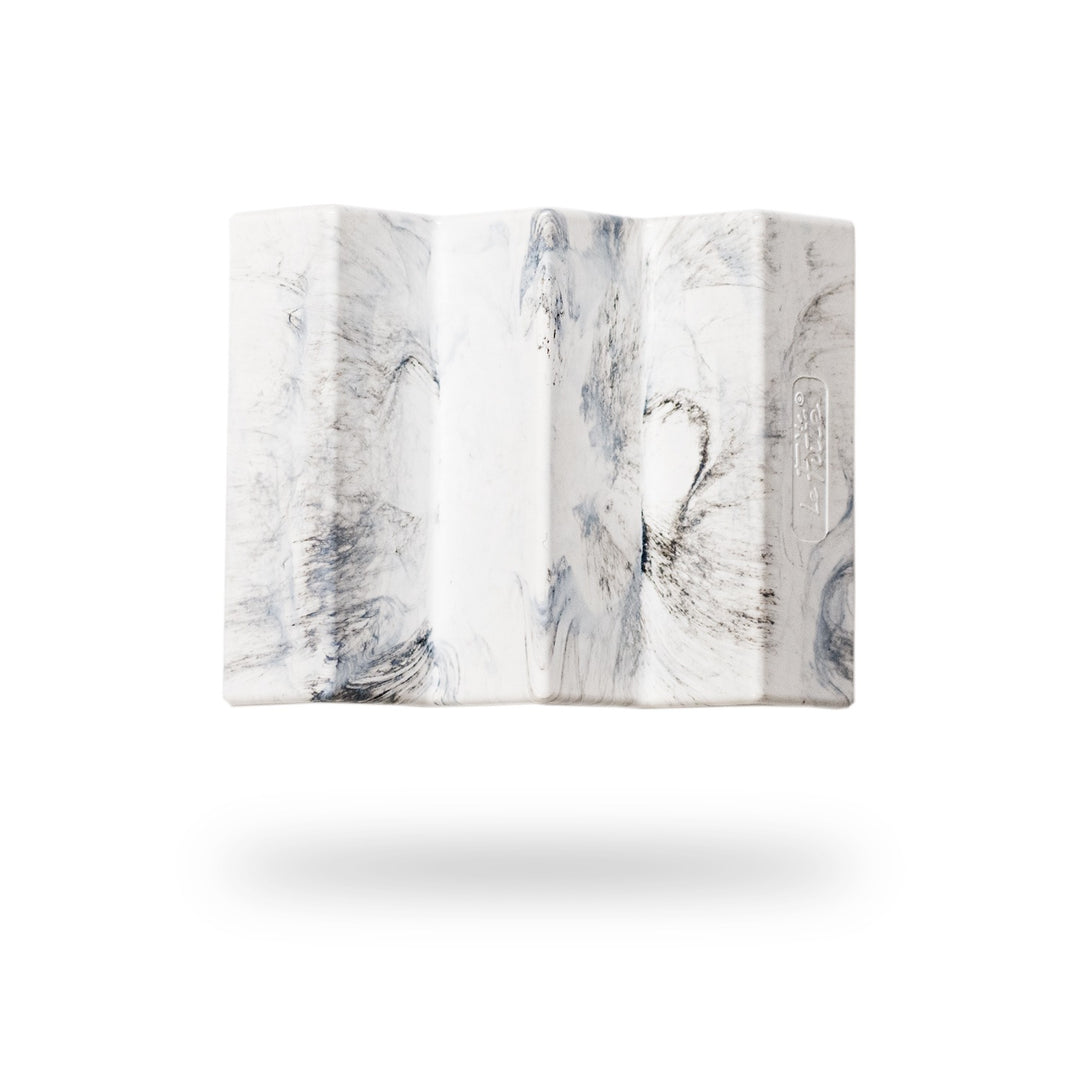 Image présentant le porte-savon Le Futé de la marque Capitaine Cosmétiques. Le visuel montre un porte-savon au design unique, avec des motifs marbrés beige et noir, flottant sur un fond blanc minimaliste.