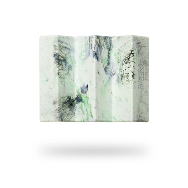 Image présentant le porte-savon Le Futé de la marque Capitaine Cosmétiques. Le visuel montre un porte-savon au design unique, avec des motifs marbrés vert et noir, flottant sur un fond blanc minimaliste.