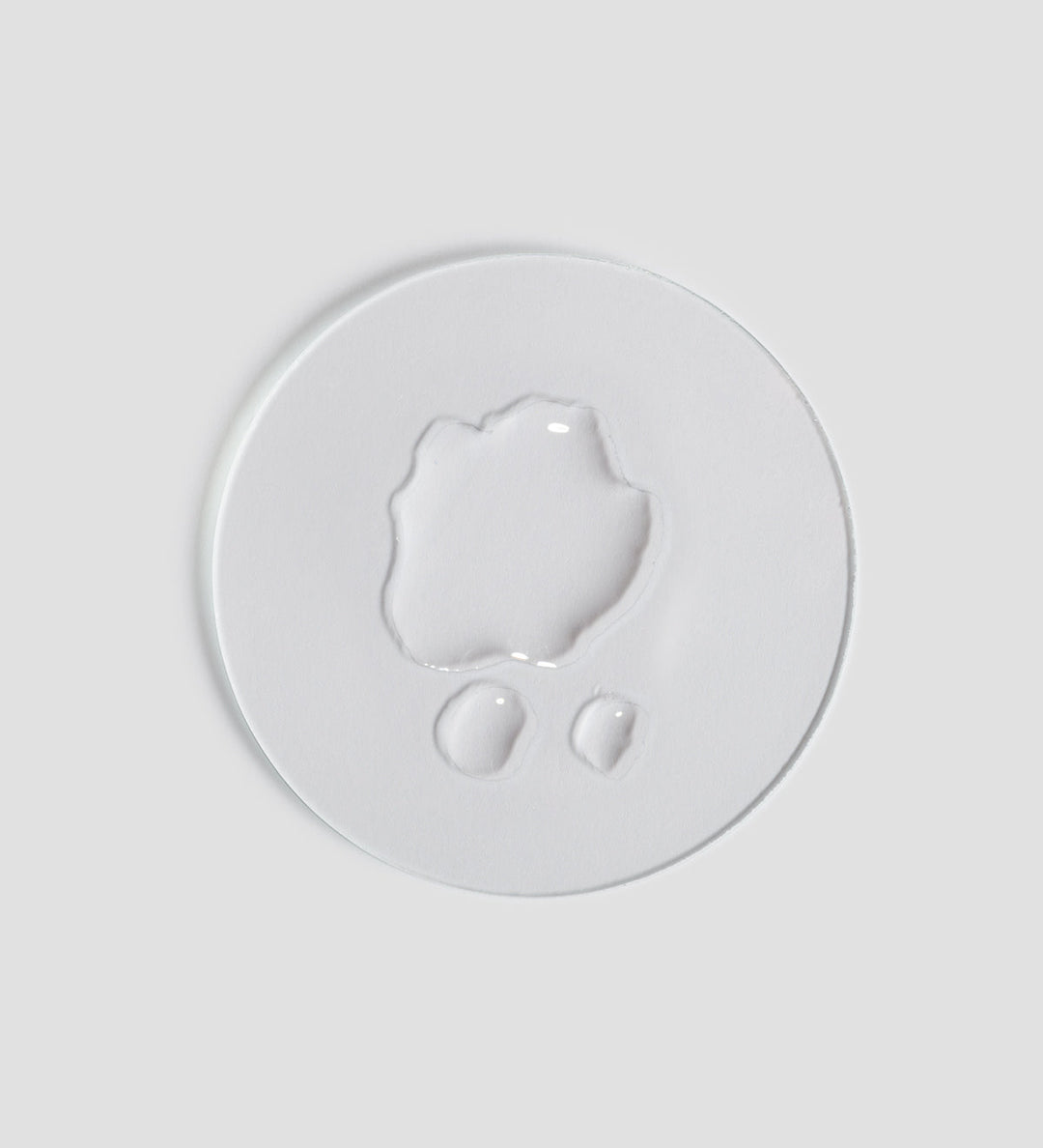 Gros plan de la texture du toner apaisant Remedy de Comfort Zone, montré sur un fond blanc clair. Le toner est translucide et présente une texture liquide.
