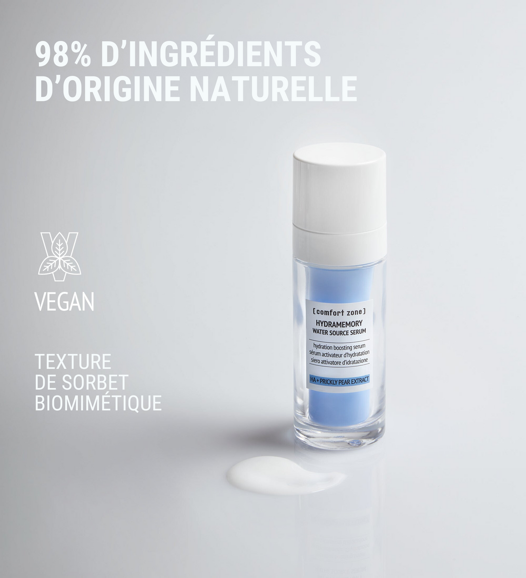 Affiche publicitaire de [comfort zone] montrant le sérum Hydramemory Water Source Serum. Le texte "98% d'ingrédients d'origine naturelle" figure en haut, avec une icône indiquant que le produit est vegan et la mention "Texture de sorbet biomimétique". Le sérum est présenté en flacon pompe, avec une texture liquide visible à côté du flacon.