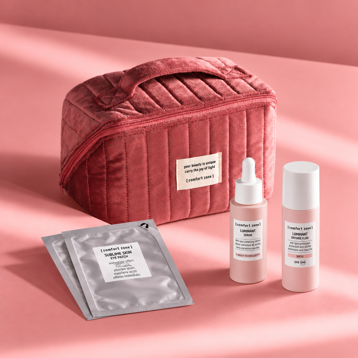 Coffret The Radiant Skin Ritual Comfort Zone avec le sérum Luminant, le fluide SPF 50+, les patchs Sublime Skin et une trousse rose.