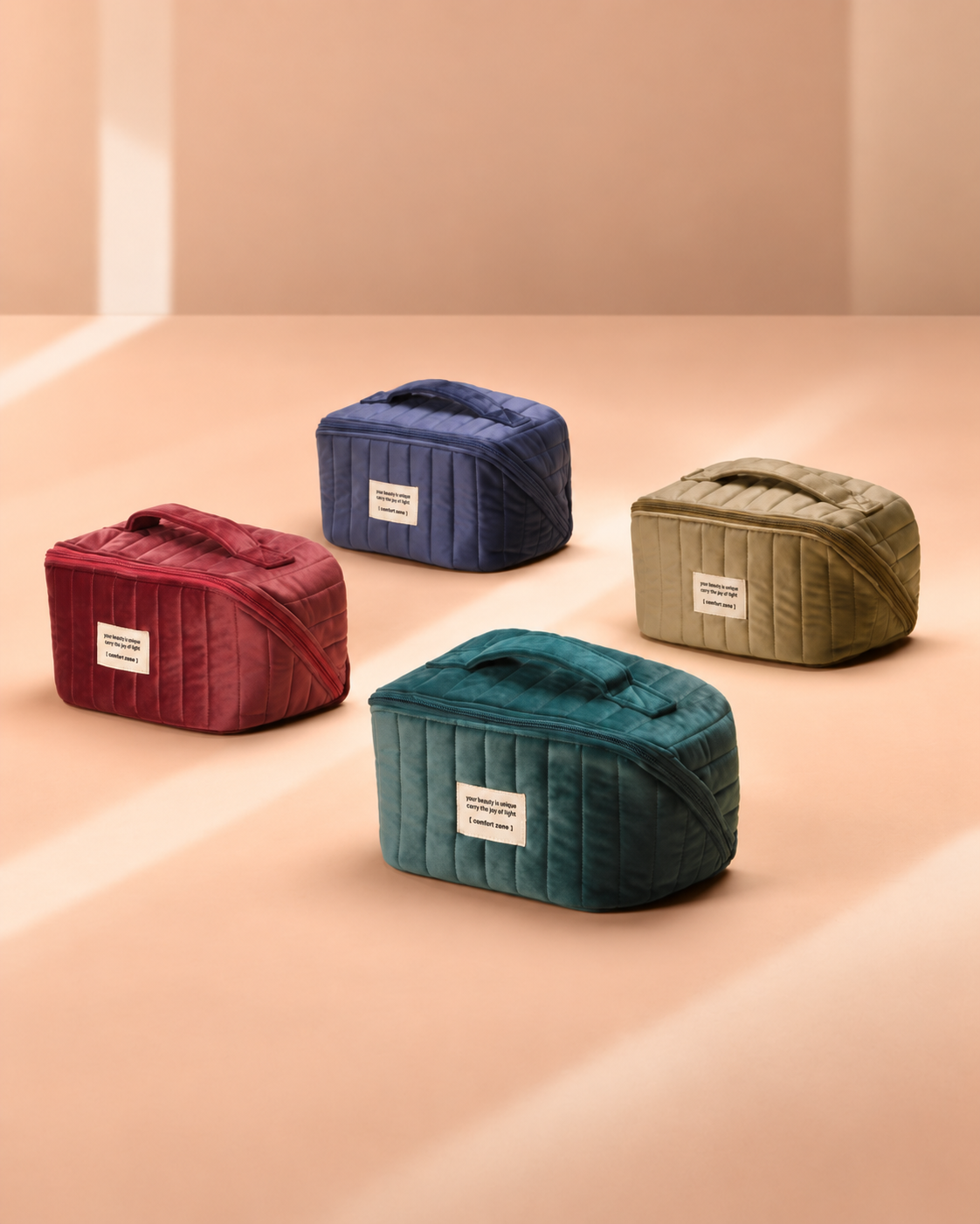 Quatre trousses cadeaux Comfort Zone de Noël, en velours rose, bleu, doré et vert.