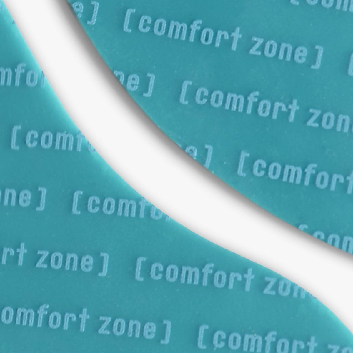 Gros plan des patchs turquoise en silicone, avec le motif Comfort Zone imprimé sur leur surface.