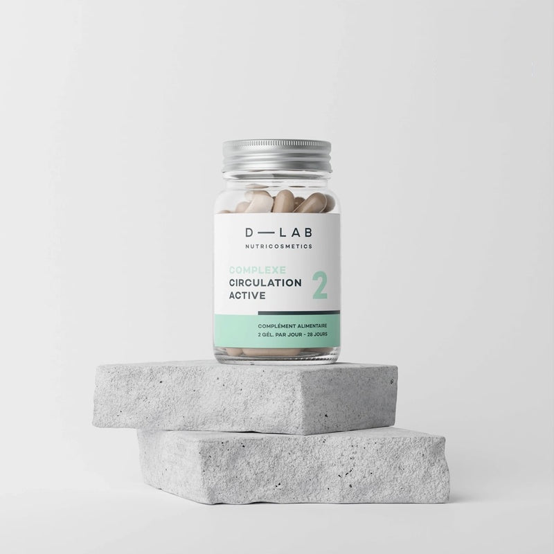 Bouteille de compléments alimentaires D-LAB Nutricosmetics Complexe Circulation Active posée sur des blocs de béton