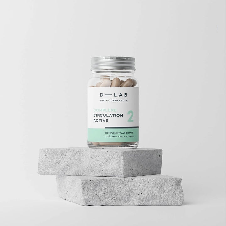 Bouteille de compléments alimentaires D-LAB Nutricosmetics Complexe Circulation Active posée sur des blocs de béton