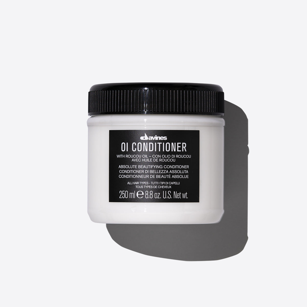 Pot de Davines OI Conditioner de 250 ml avec huile de roucou. Un conditionneur embellisseur absolu adapté à tous les types de cheveux, présenté sur un fond blanc avec son étiquette noire distincte.