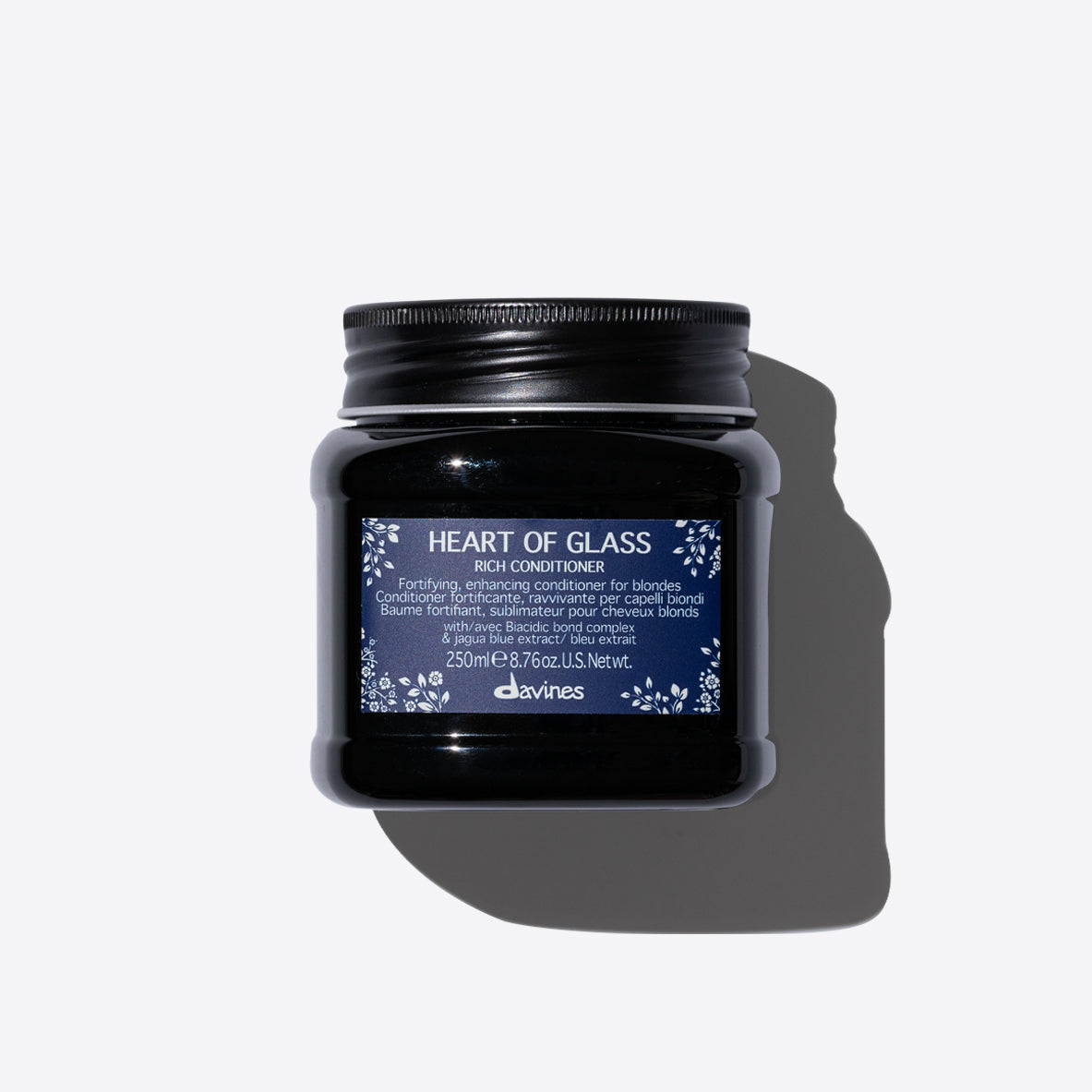 Conditionneur fortifiant et rehausseur pour cheveux blonds Davines Heart of Glass Rich Conditioner, 250ml, avec un complexe Biacidic Bond et un extrait bleu de jagua, présenté dans un pot noir avec une étiquette bleue et blanche.