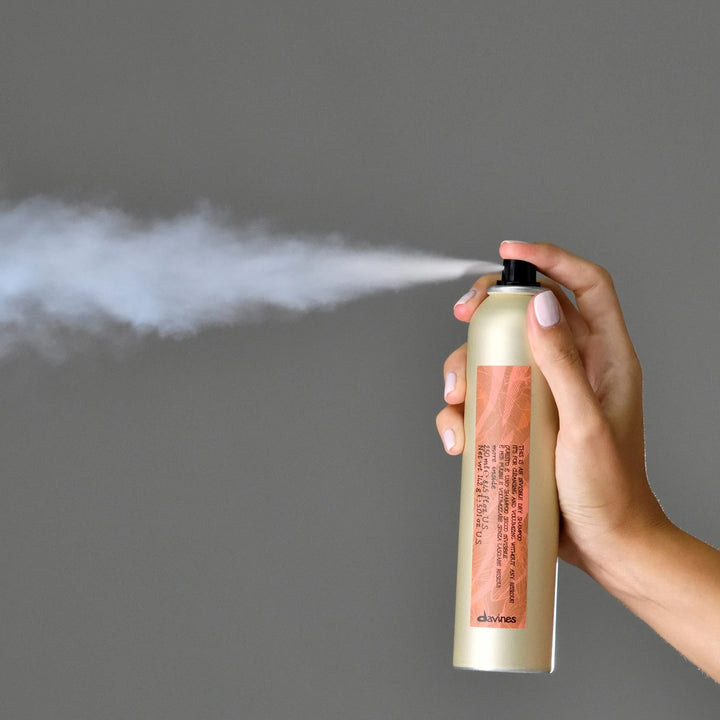 Diffusion du Davines Invisible Dry Shampoo vaporisé sur cheveux pour rafraîchir les racines.