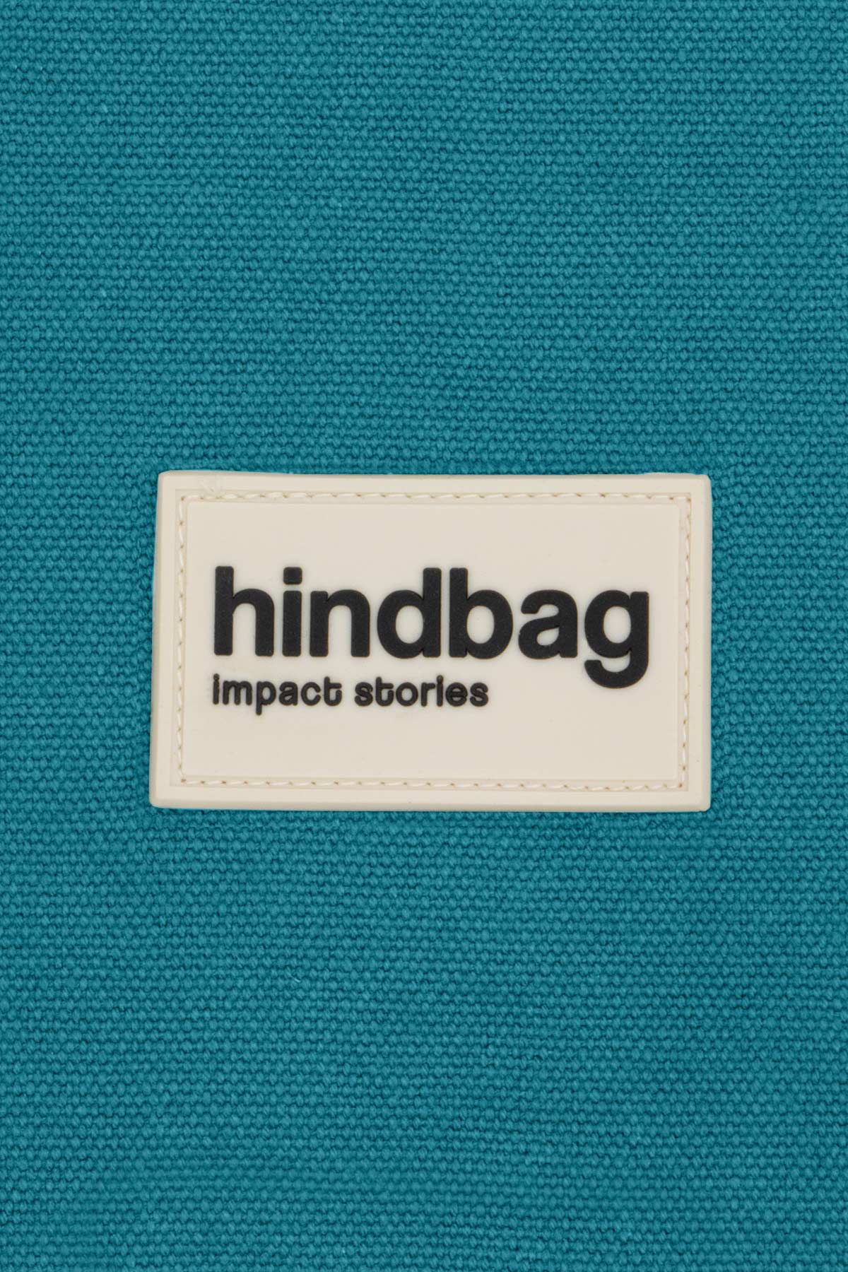 Detail du logo Hindbag sur le Sling Bag Felix Bleu Paon en coton epais texture