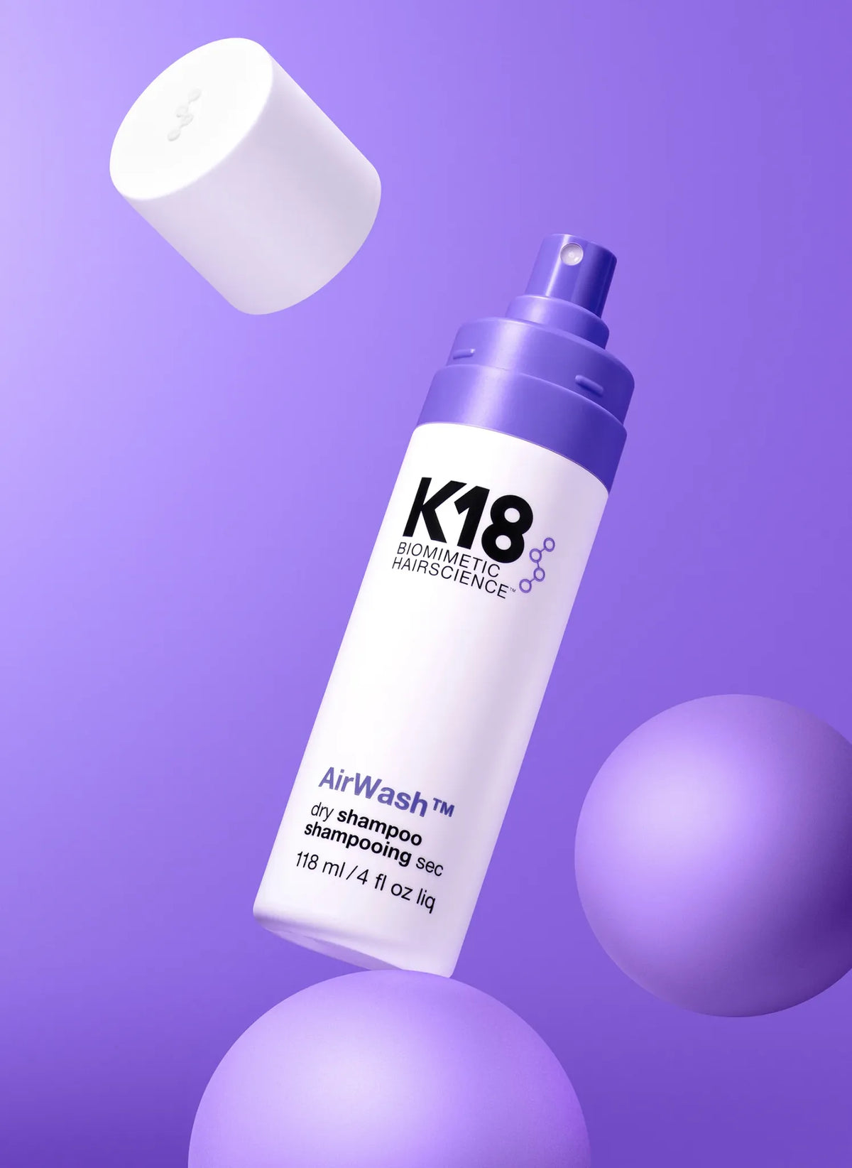 Flacon K18 AirWash™ ouvert, avec son capuchon détaché et son vaporisateur visible sur fond violet.