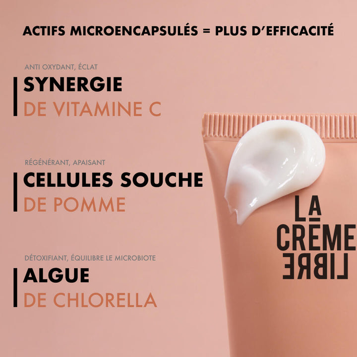 Crème Originale La Crème Libre avec actifs microencapsulés : synergie de vitamine C pour l’éclat, cellules souches de pomme régénérantes et algue de chlorella détoxifiante. Visuel tube rose avec texture visible sur fond ton sur ton.