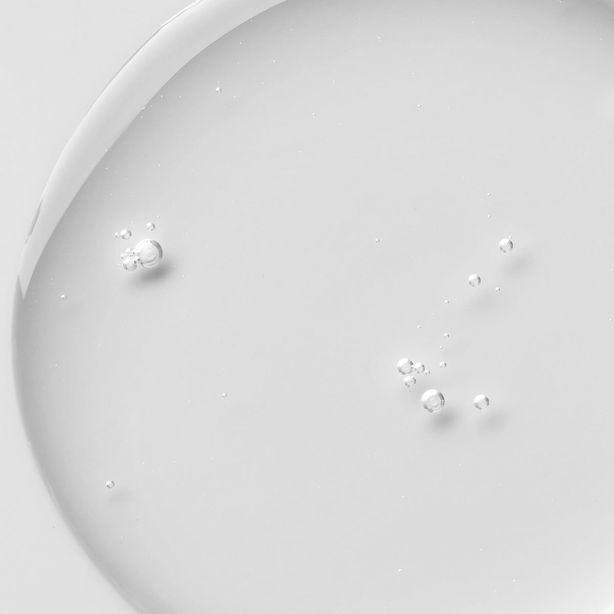 Gros plan sur la texture translucide du Luminant PHA Essence Toner, avec quelques bulles visibles.