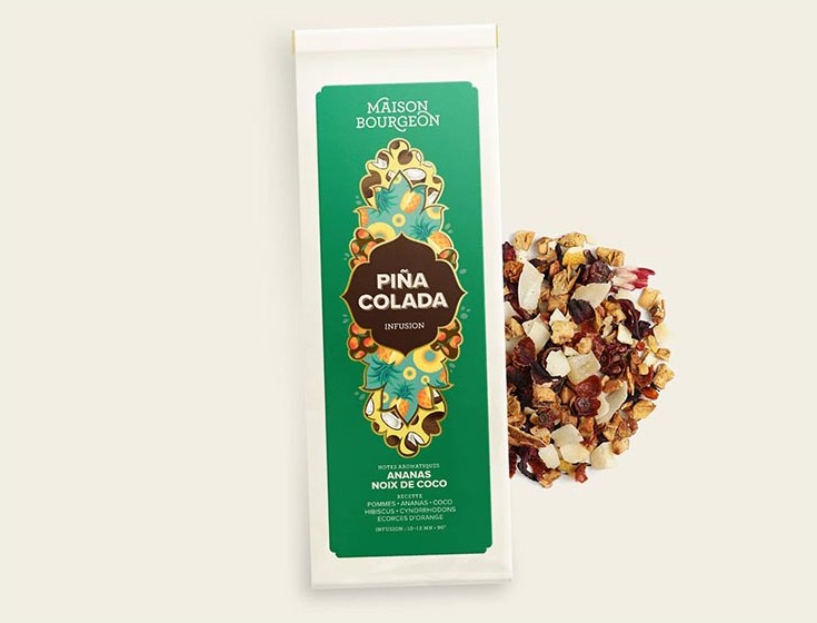 Image du produit "PIÑA COLADA" de la marque Maison Bourgeon, montrant un paquet de tisane aromatisée avec des morceaux d'ananas et de noix de coco. Le paquet est à côté d'un mélange d'infusion en vrac, mettant en valeur les ingrédients naturels visibles dans la tisane.