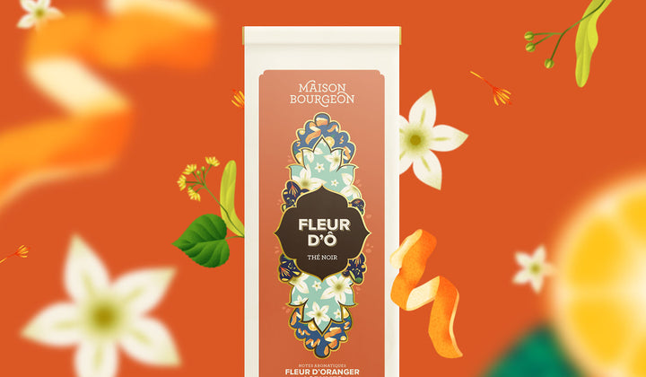 Paquet de thé noir Maison Bourgeon Fleur d'O avec des illustrations de fleurs d'oranger et de zestes d'orange en arrière-plan.