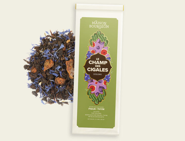 Thé Oolong Le Champ des Cigales de Maison Bourgeon, affichant un mélange riche de feuilles de thé, de morceaux de figue et de fleurs de bleuet, offrant une expérience de dégustation aromatique et visuellement attrayante.