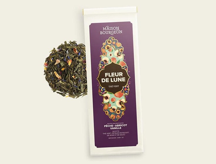 Image du produit "FLEUR DE LUNE" de la marque Maison Bourgeon, montrant un paquet de thé vert aromatisé avec des saveurs de pêche, d'abricot et de vanille. Le paquet est à côté d'un mélange de thé en vrac, mettant en valeur les morceaux de fruits et les pétales de fleurs naturels visibles dans le thé.
