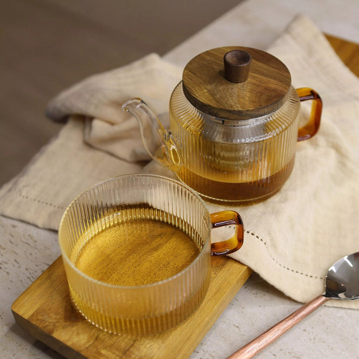 Théière OGO Living KAR en verre nervuré avec tasse assortie sur table en bois et linge beige