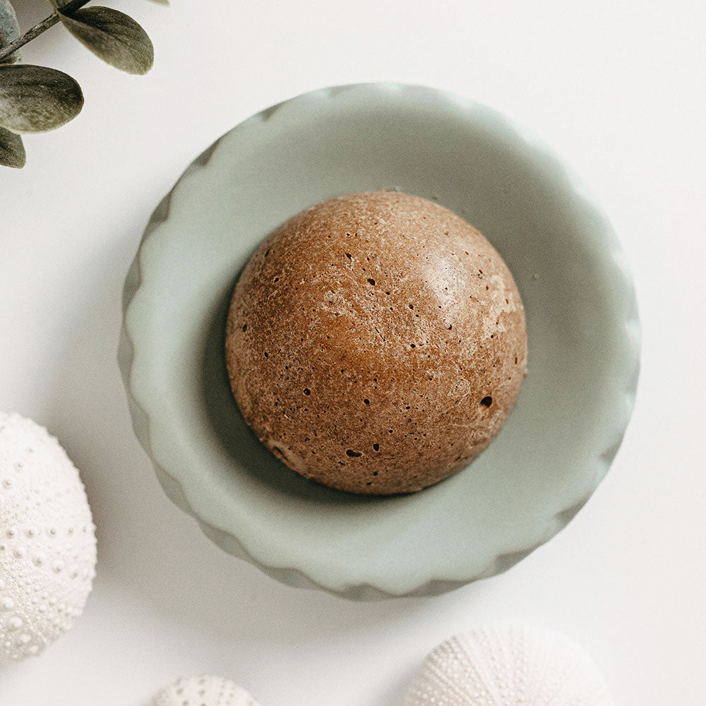 Shampoing solide usage quotidien Wilmotte Cosmétique en forme de boule, présenté dans une coupelle vert d’eau sur fond blanc. Formule douce sans huiles essentielles, enrichie en chanvre bio et shikakai, idéale pour toute la famille.